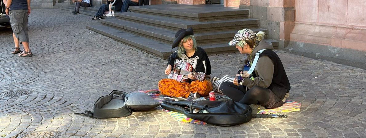 Ungewöhnlich drapierte Straßenmusiker, die wie aus einem Charles-Dickens-Film aussehen